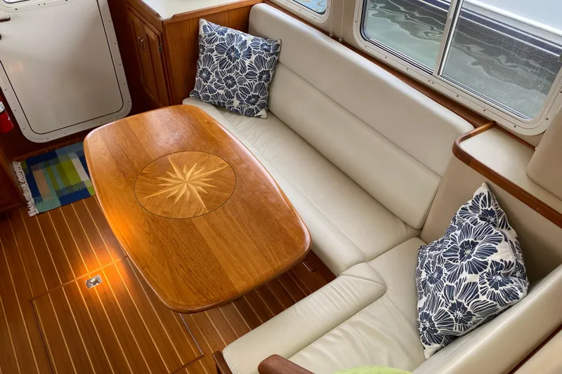 Emilie B Yacht Photos Pics Cozy interior of 2003 American Tug 34 with elegant wood table and plush seating.