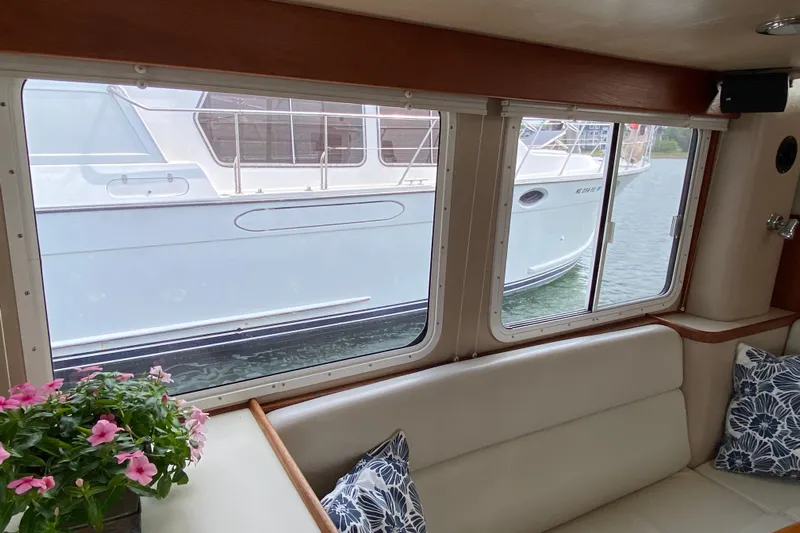 Emilie B Yacht Photos Pics Interior view of a 2003 American Tug 34, featuring a cozy seating area with floral decor.