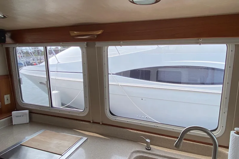 Emilie B Yacht Photos Pics Interior view from 2003 American Tug 34, showcasing kitchen sink and marina scene.