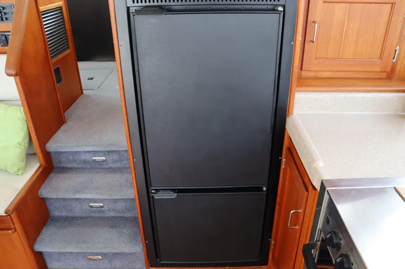 Emilie B Yacht Photos Pics Interior of 2003 American Tug 34, featuring stairs and kitchen area with refrigerator.