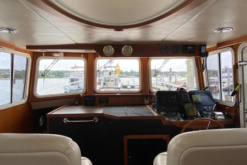 Emilie B Yacht Photos Pics Interior view of 2003 American Tug 34 pilothouse with navigation equipment and scenic harbor view.