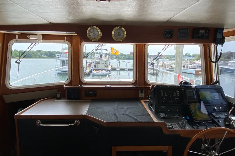 Emilie B Yacht Photos Pics Pilothouse interior of 2003 American Tug 34, featuring navigation equipment and waterfront view.