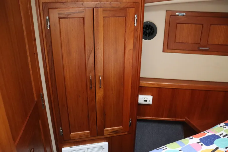 Emilie B Yacht Photos Pics Interior of 2003 American Tug 34 with wooden cabinetry and colorful bedding.