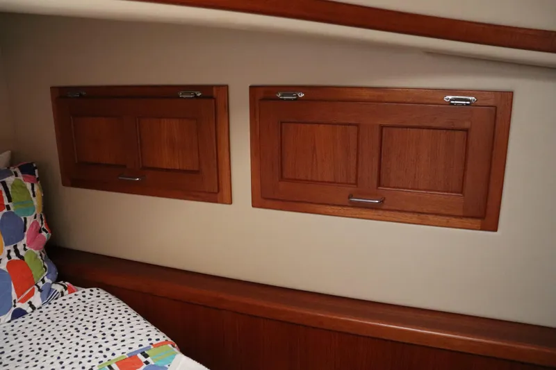 Emilie B Yacht Photos Pics Interior of 2003 American Tug 34 with wooden cabinets and colorful bedding.