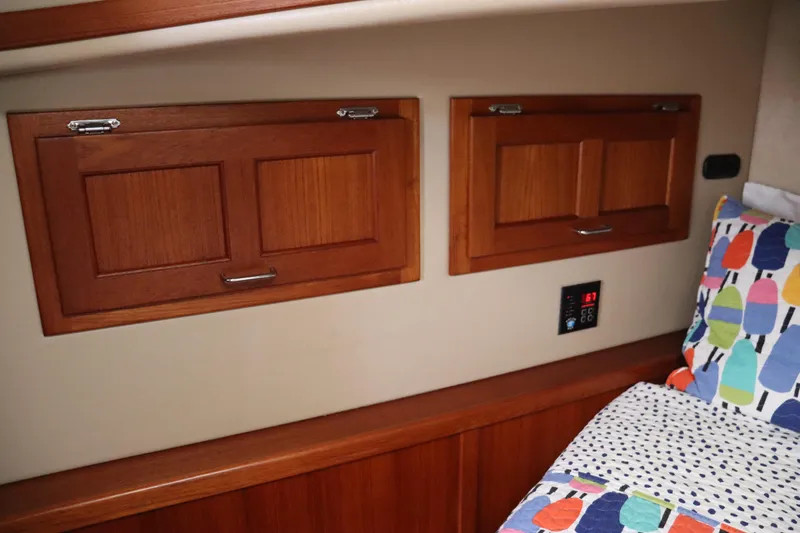 Emilie B Yacht Photos Pics Interior of 2003 American Tug 34 with wooden cabinets and colorful bedding.