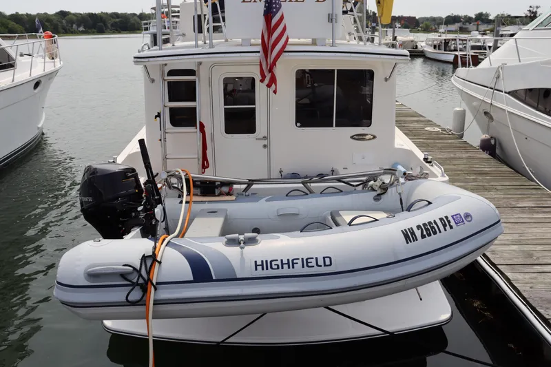 Emilie B Yacht Photos Pics American Tug 34 (2003) docked with inflatable boat, displaying American flag.