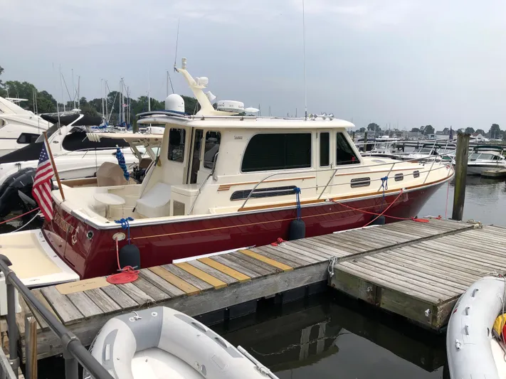  Yacht Photos Pics 2009 Sabre 40 Sedan boat docked at marina, featuring red hull and American flag.