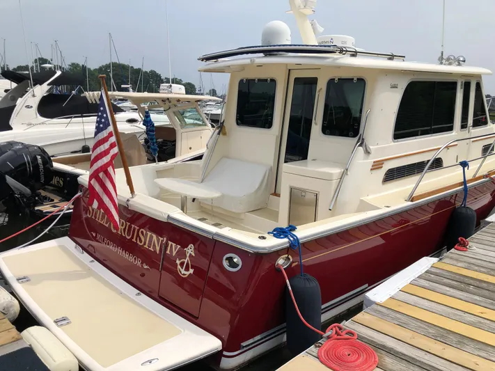  Yacht Photos Pics 2009 Sabre 40 Sedan boat docked, featuring red hull and American flag.