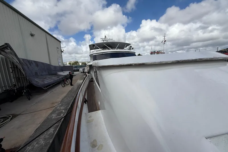  Yacht Photos Pics 1990 Denison Pilothouse Cockpit Motoryacht docked beside a warehouse under cloudy skies.