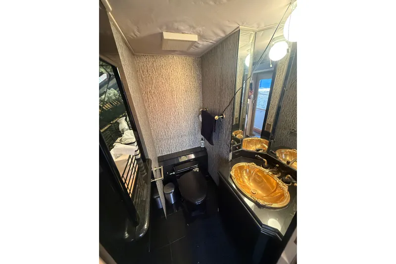  Yacht Photos Pics Luxurious bathroom in 1990 Denison Pilothouse Cockpit Motoryacht with gold sink and modern fixtures.