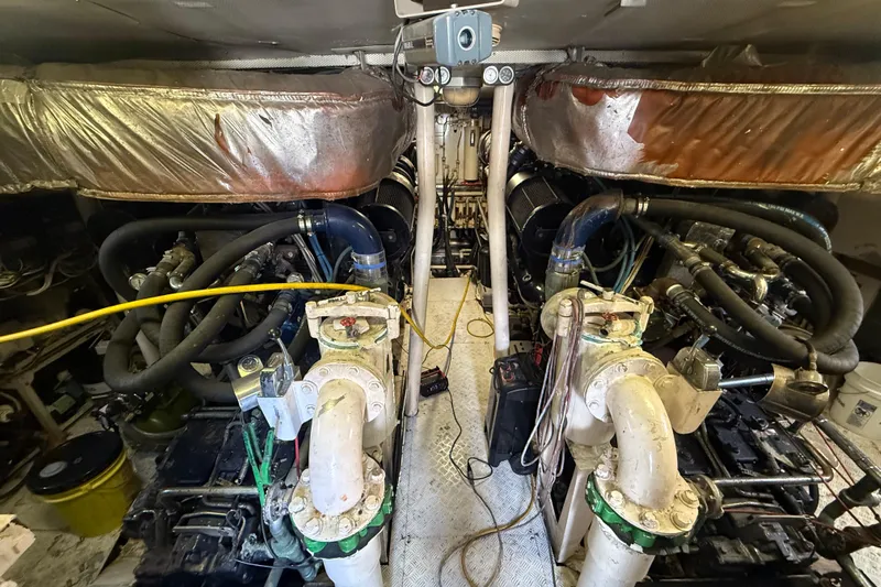  Yacht Photos Pics Engine room of a 1990 Denison Pilothouse Cockpit Motoryacht, showcasing complex machinery and piping.