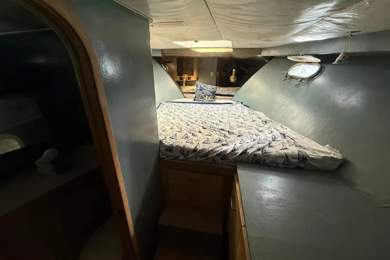  Yacht Photos Pics Cozy cabin interior of 1990 Denison Pilothouse Cockpit Motoryacht with nautical-themed bedding.