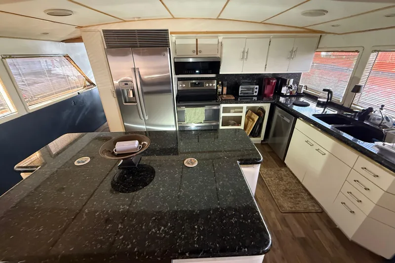  Yacht Photos Pics Luxurious kitchen in 1990 Denison Pilothouse Cockpit Motoryacht with modern appliances and granite countertops.