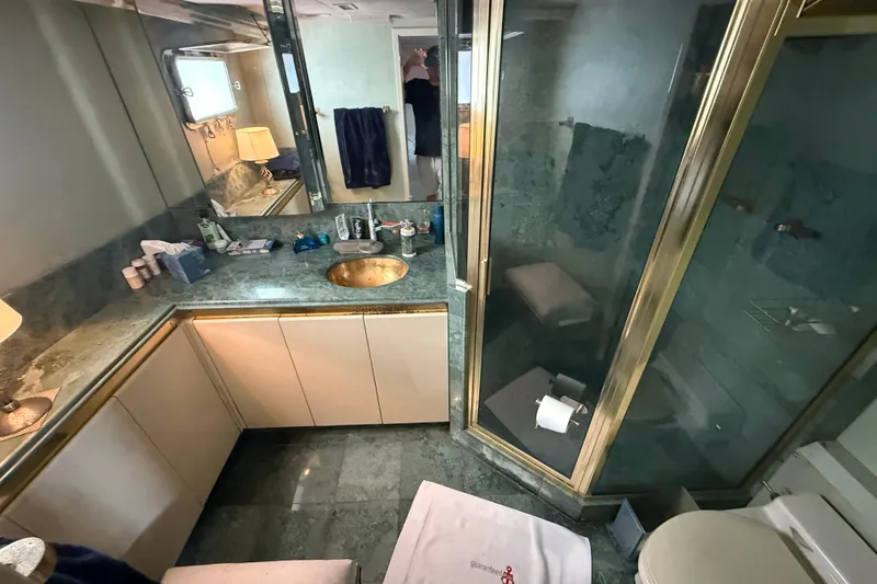  Yacht Photos Pics Luxurious bathroom in 1990 Denison Pilothouse Cockpit Motoryacht with marble countertops and glass shower.