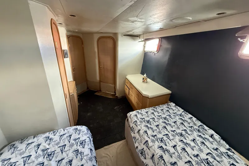  Yacht Photos Pics 1990 Denison Pilothouse Motoryacht cabin with twin beds and nautical-themed bedding.