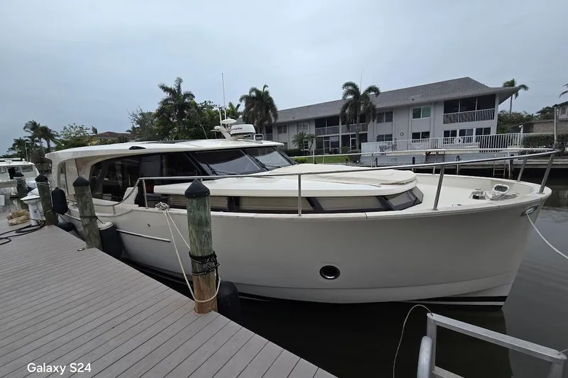 Green Eye Lady Yacht Photos Pics 2019 Greenline 40 yacht docked at marina, surrounded by palm trees and waterfront homes.