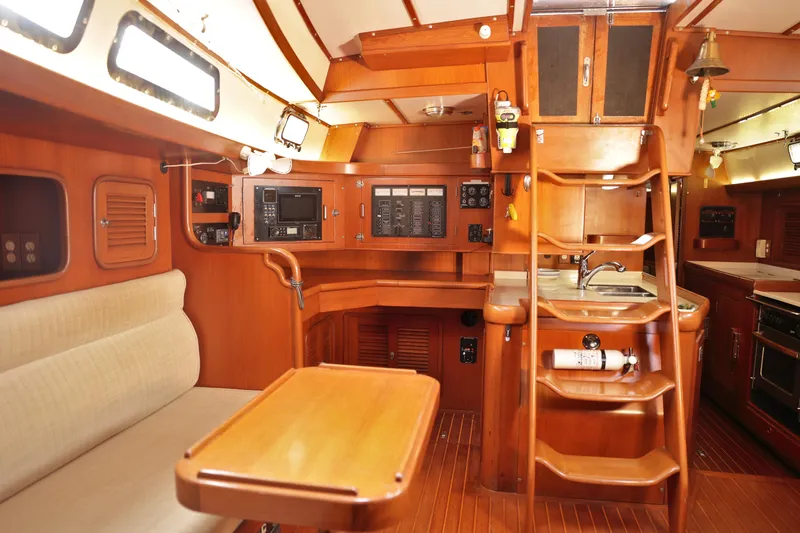 Oleta Yacht Photos Pics Interior of 2005 Tayana 48 yacht with wooden furnishings and compact kitchen area.