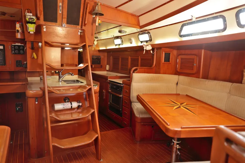 Oleta Yacht Photos Pics Luxurious 2005 Tayana 48 yacht interior with wooden finishes, kitchen, and dining area.