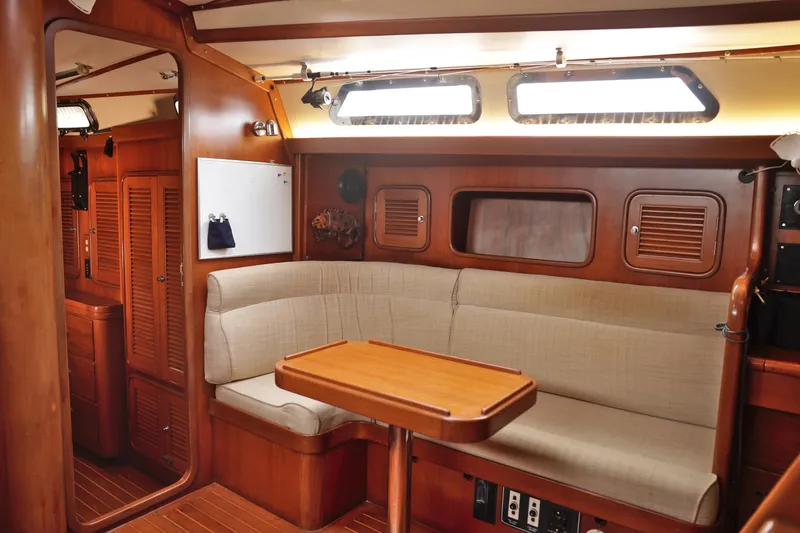 Oleta Yacht Photos Pics Interior of 2005 Tayana 48 yacht with wooden furnishings and beige seating.