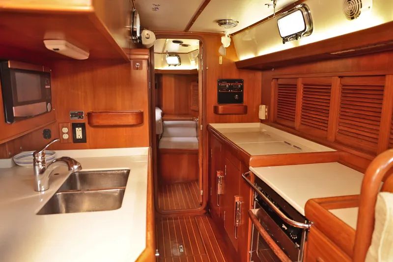 Oleta Yacht Photos Pics Interior of 2005 Tayana 48 yacht with wooden cabinetry and modern kitchen amenities.