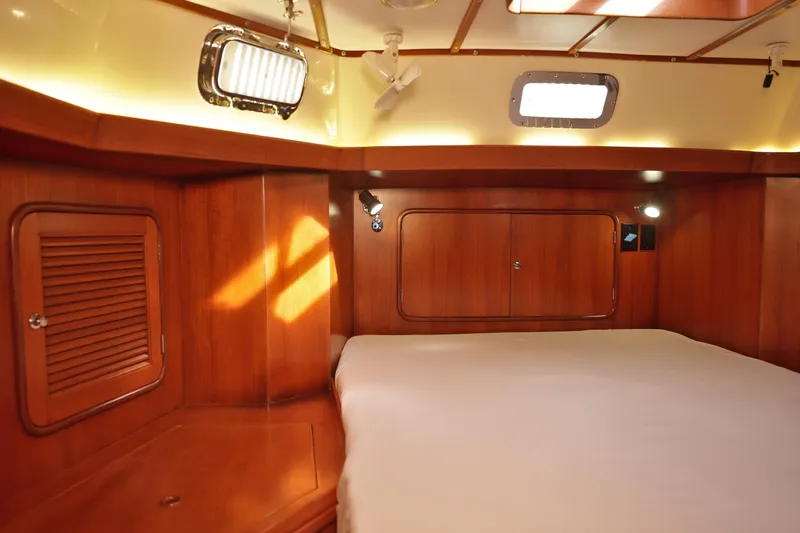 Oleta Yacht Photos Pics Luxurious wooden interior of 2005 Tayana 48 yacht cabin with cozy bed and ambient lighting.