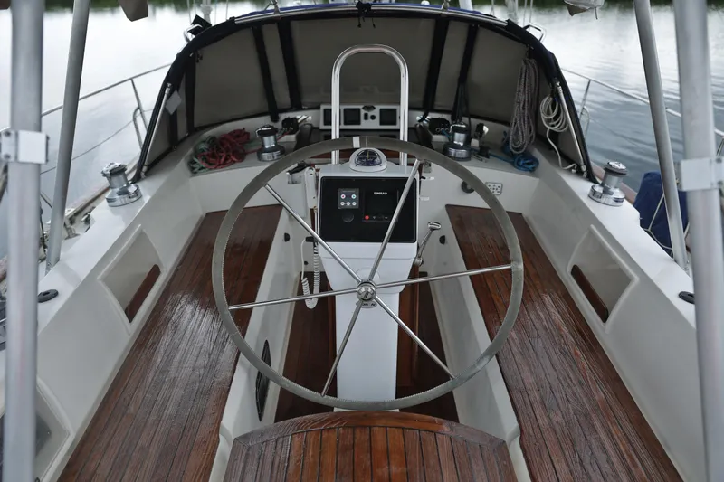 Oleta Yacht Photos Pics Cockpit of 2005 Tayana 48 sailboat with wooden seating and steering wheel.