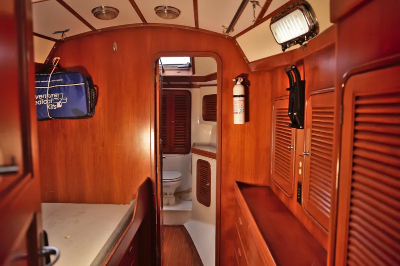 Oleta Yacht Photos Pics Interior of 2005 Tayana 48 yacht with wooden cabinetry and visible bathroom.