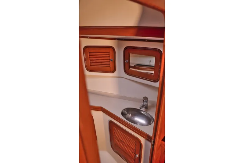 Oleta Yacht Photos Pics Interior of 2005 Tayana 48 yacht bathroom with wooden cabinets and stainless steel sink.