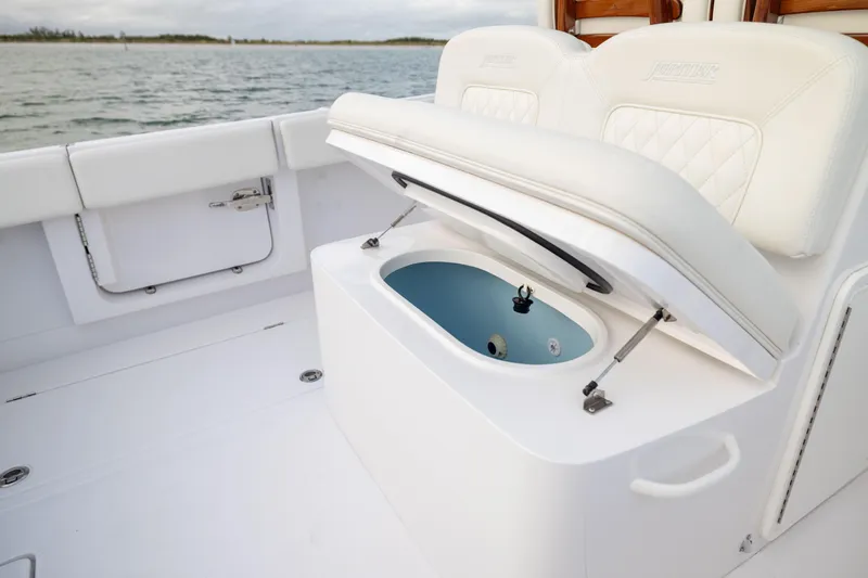  Yacht Photos Pics 2022 Jupiter 38 HFS boat with open storage compartment, white seating, and ocean backdrop.