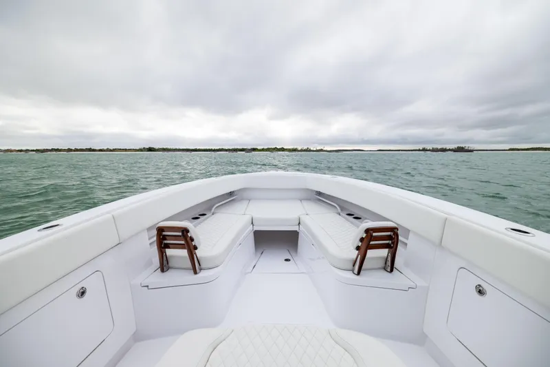  Yacht Photos Pics 2022 Jupiter 38 HFS boat interior with white seating, on open water under cloudy skies.