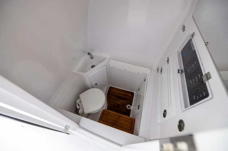  Yacht Photos Pics 2022 Jupiter 38 HFS boat bathroom with toilet, sink, and wooden flooring.