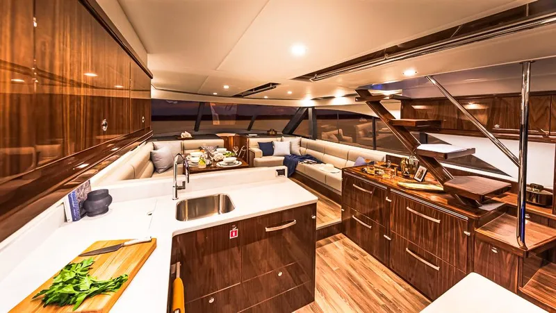  Yacht Photos Pics Luxurious interior of 2023 Riviera 57 Enclosed Flybridge yacht with modern kitchen and seating area.