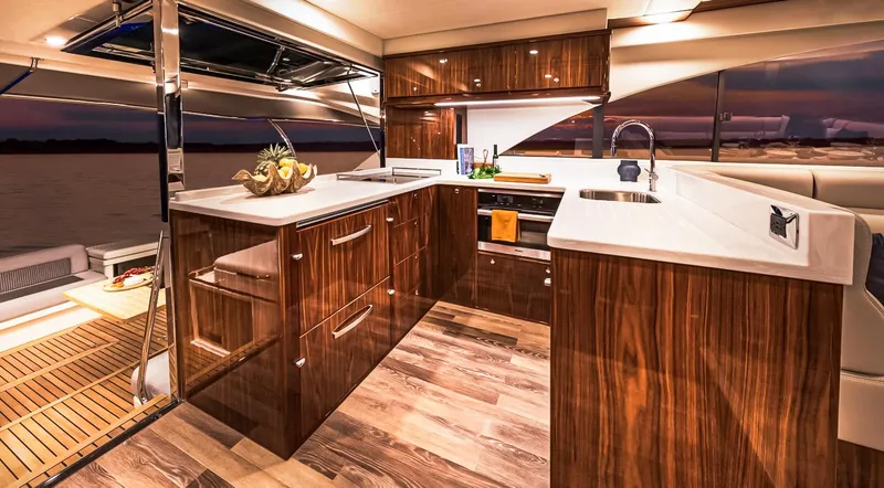 Yacht Photos Pics Luxurious kitchen interior of 2023 Riviera 57 Enclosed Flybridge yacht at sunset.