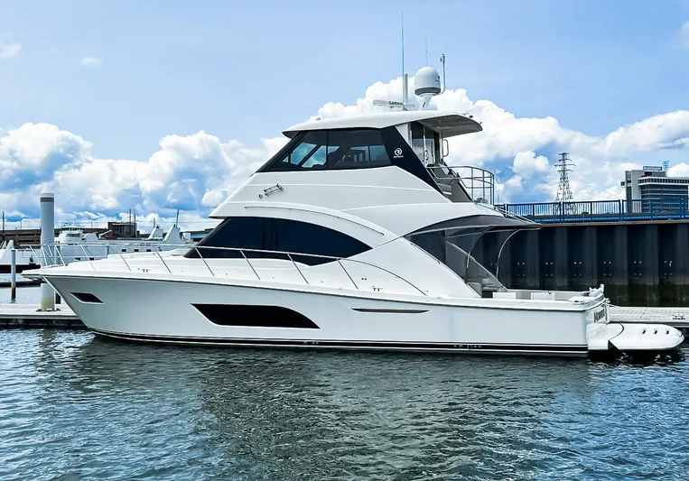  Yacht Photos Pics 2023 Riviera 57 Enclosed Flybridge yacht docked at marina under blue sky.