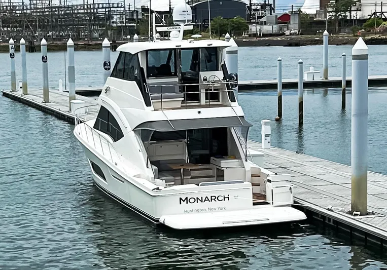  Yacht Photos Pics 2023 Riviera 57 Enclosed Flybridge yacht docked at marina, rear view.