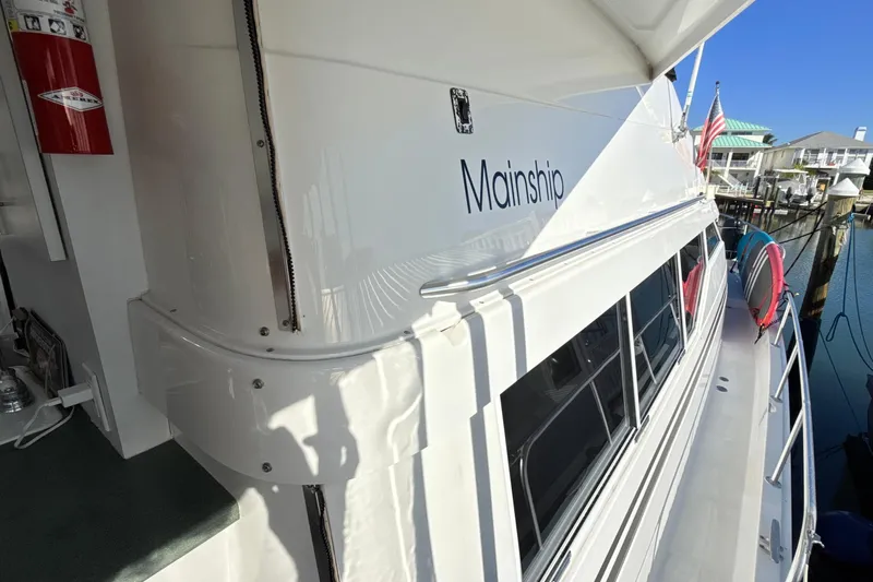 Cole-lateral Damage Yacht Photos Pics 1998 Mainship 47 Motor Yacht docked, showcasing sleek design and spacious deck.