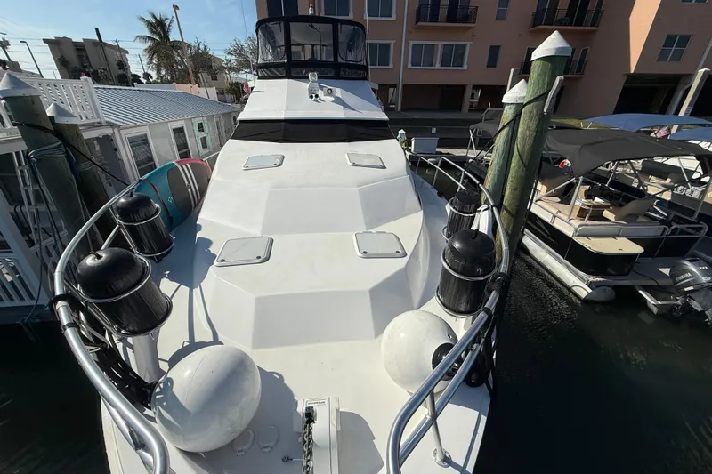 Cole-lateral Damage Yacht Photos Pics 1998 Mainship 47 Motor Yacht docked at marina, surrounded by other boats.