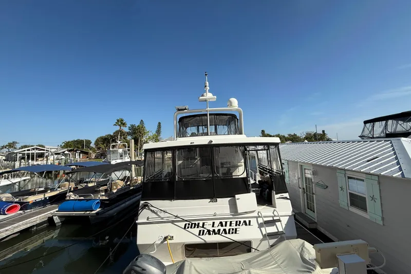 Cole-lateral Damage Yacht Photos Pics 1998 Mainship 47 Motor Yacht docked at marina under clear blue sky.