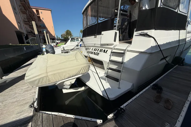 Cole-lateral Damage Yacht Photos Pics 1998 Mainship 47 Motor Yacht docked with covered dinghy and visible ladder.