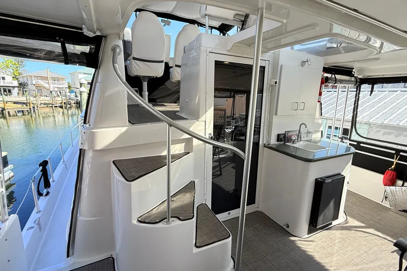 Cole-lateral Damage Yacht Photos Pics 1998 Mainship 47 Motor Yacht interior with spiral staircase and kitchenette.