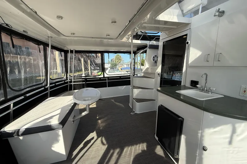 Cole-lateral Damage Yacht Photos Pics Interior of 1998 Mainship 47 Motor Yacht with seating, kitchenette, and spiral staircase.