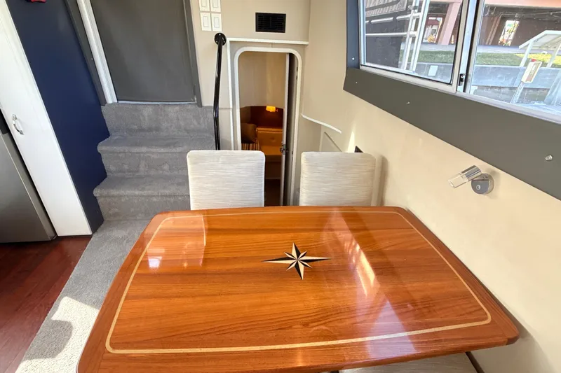 Cole-lateral Damage Yacht Photos Pics Interior of 1998 Mainship 47 Motor Yacht with elegant wooden table and seating.