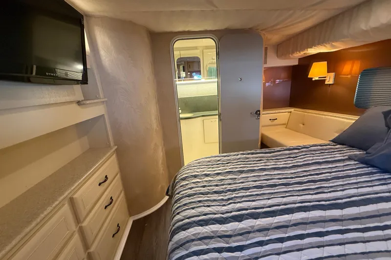 Cole-lateral Damage Yacht Photos Pics Interior of 1998 Mainship 47 Motor Yacht bedroom with bed, TV, and storage.