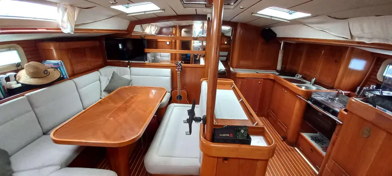 Roxanne Yacht Photos Pics Interior of 1990 Beneteau Oceanis Clipper 500 yacht with wood finish and cozy seating area.
