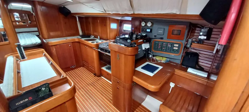 Roxanne Yacht Photos Pics Interior of 1990 Beneteau Oceanis Clipper 500 yacht, featuring wood paneling and navigation equipment.
