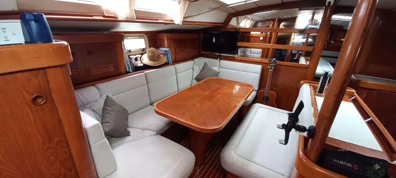 Roxanne Yacht Photos Pics Interior of 1990 Beneteau Oceanis Clipper 500 yacht with wooden furnishings and white seating.