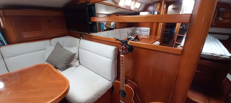 Roxanne Yacht Photos Pics Interior of 1990 Beneteau Oceanis Clipper 500 yacht with cozy seating and guitar.