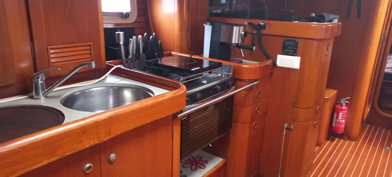 Roxanne Yacht Photos Pics Interior of 1990 Beneteau Oceanis Clipper 500 yacht kitchen with wooden cabinetry.