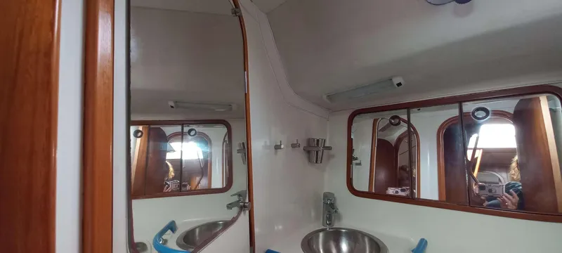 Roxanne Yacht Photos Pics Interior of 1990 Beneteau Oceanis Clipper 500 yacht bathroom with mirrors and sink.