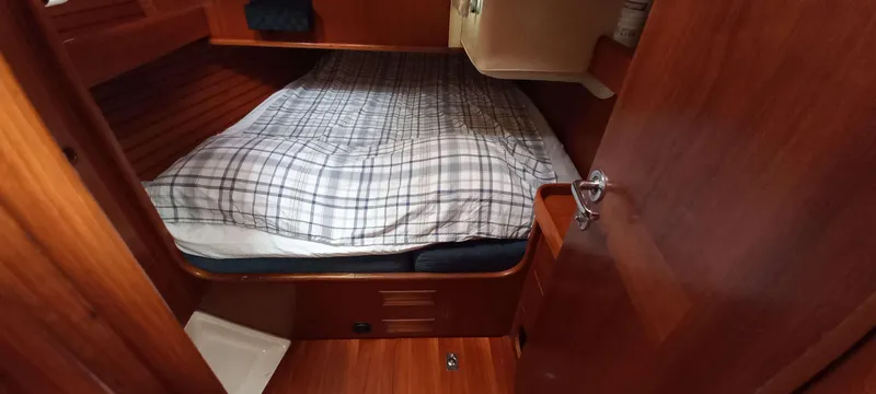 Roxanne Yacht Photos Pics Cozy cabin interior of 1990 Beneteau Oceanis Clipper 500 sailboat with plaid bedding.